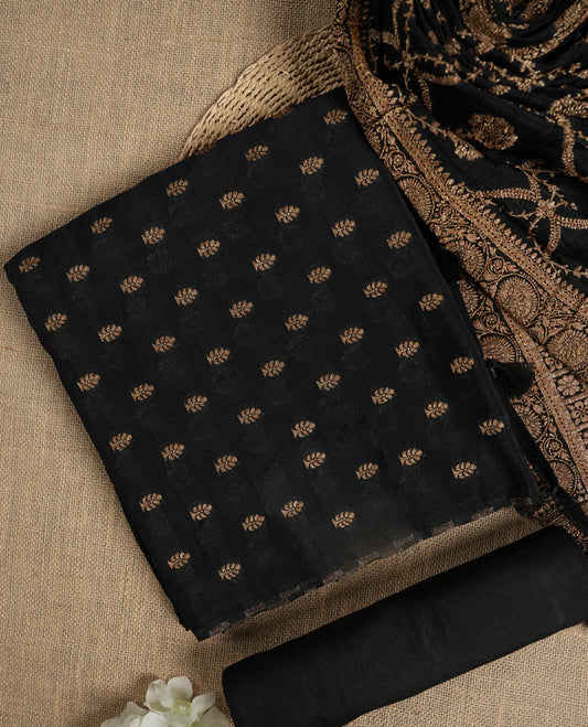 Black suit material adorned with intricate golden zari motifs weaving, exuding timeless elegance & Paired with a beautifully woven dupatta featuring floral and motifs and a matching plain bottom.