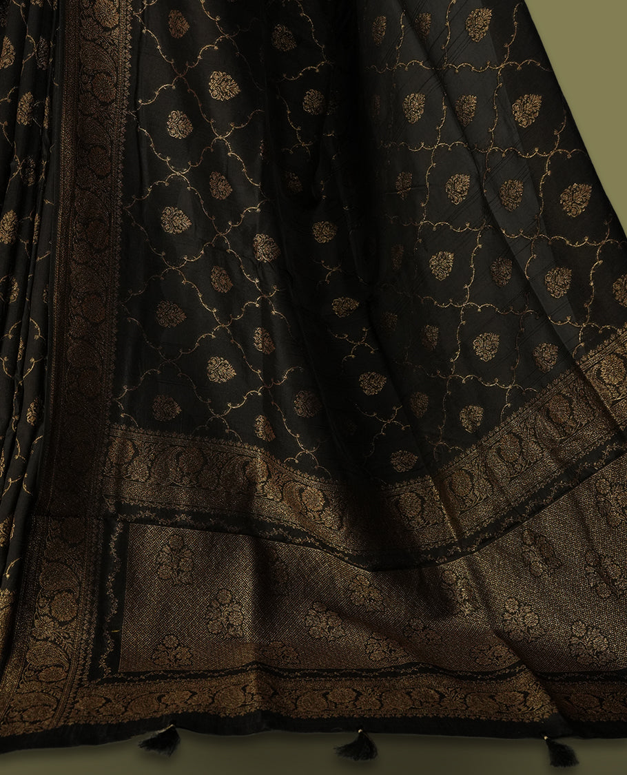 Black colour semi Banarasi Tussar Georgette saree with gold zari motifs on the body, a grand woven golden pallu, and ornate zari border, Includes a matching blouse piece for a complete look.