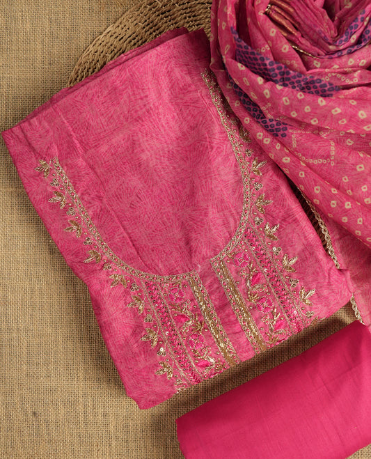 Dark pink colour suit material adorned with pearls, sequins and cut beads embroidery work on the neckline, exuding a graceful charm & Paired with a floral printed dupatta and a matching plain bottom.