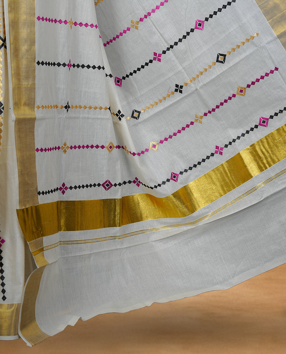 Off white colour cotton Kerala saree featuring colourful geometric motifs, complemented by a classic golden zari border and traditional pallu, paired with a matching blouse.