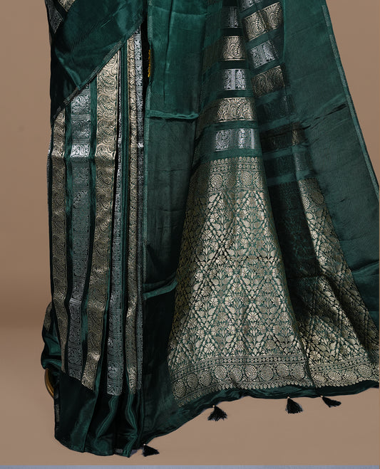 Green colour banaras crepe saree featuring gold & silver zari design stripes on body, complemented by self colour border, paired with matching blouse piece.