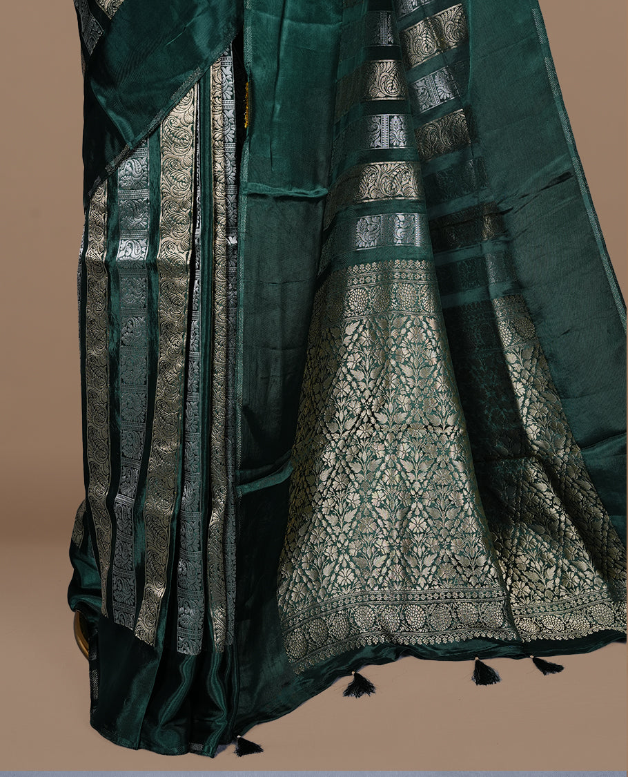Green colour banaras crepe saree featuring gold & silver zari design stripes on body, complemented by self colour border, paired with matching blouse piece.