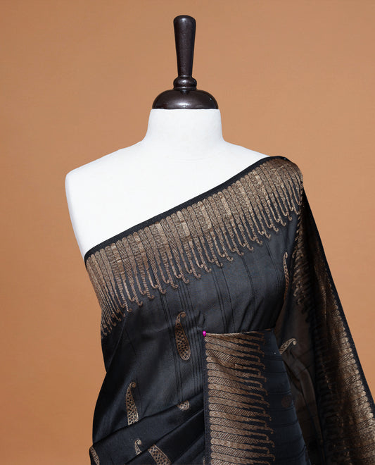 Black colour Semi Banaras Tussar Georgette Featuring Gold zari Leaf pattern on body, Finished with Gold zari border and paired with matching blouse piece.