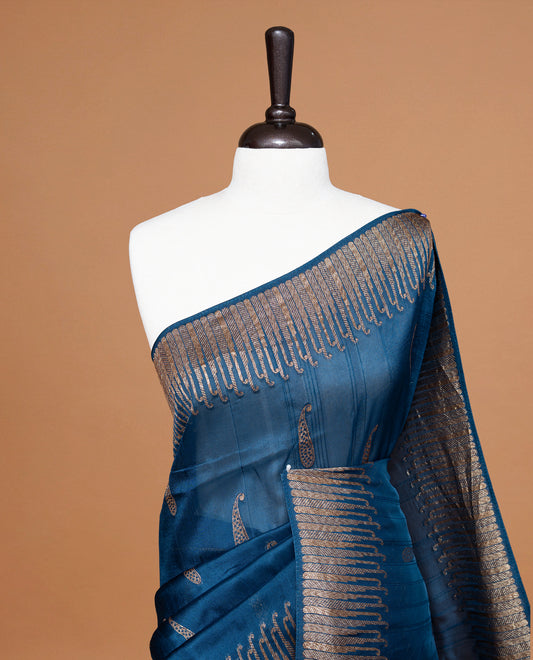 Blue colour Semi Banaras Tussar Georgette Featuring Gold zari Leaf pattern on body, Finished with Gold zari border and paired with matching blouse piece.