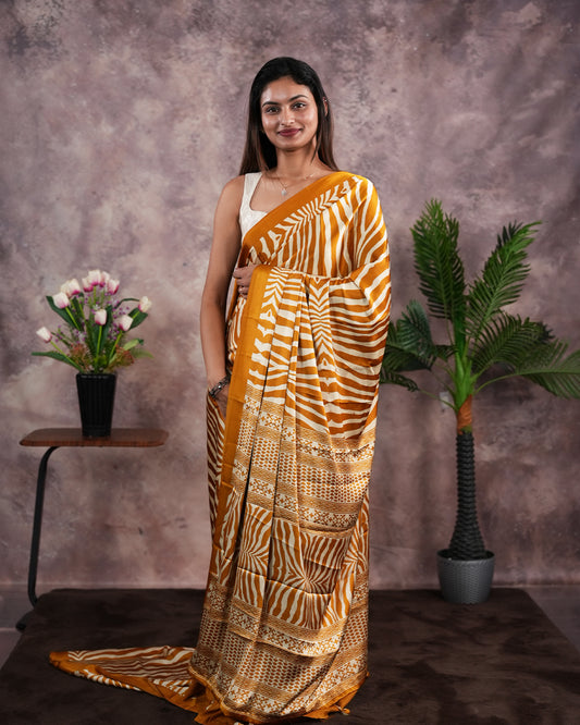 Mustard Yellow Colour satin model saree featuring Zibra print on body. Ajrak & zibra print on pallu with jhumka tassels, comes with contrast plain blouse piece.
