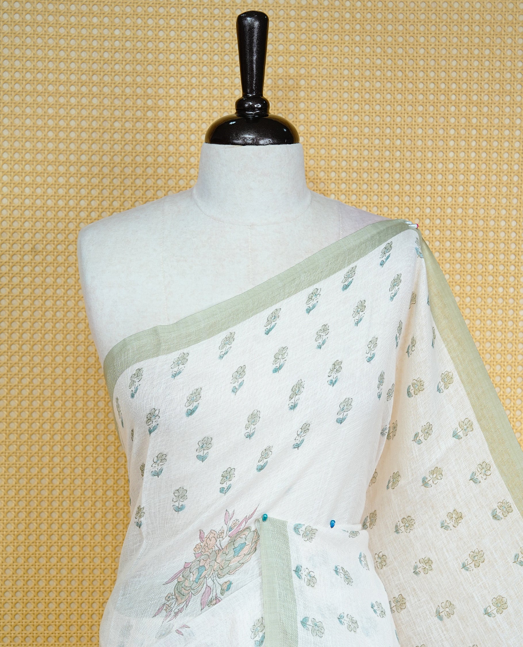 Cream colour semi linen saree featuring Light green colour floral print on body, complemented by contrast Light purple border, comes with matching blouse piece.