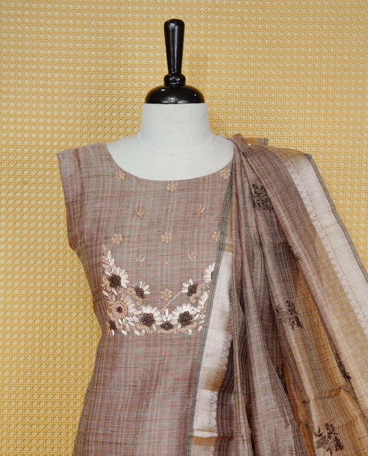 Brown colour Tissue Churidar Set featuring delicate floral embroidery and subtle bead detailing on the yoke, paired with matching solid pants and dupatta.