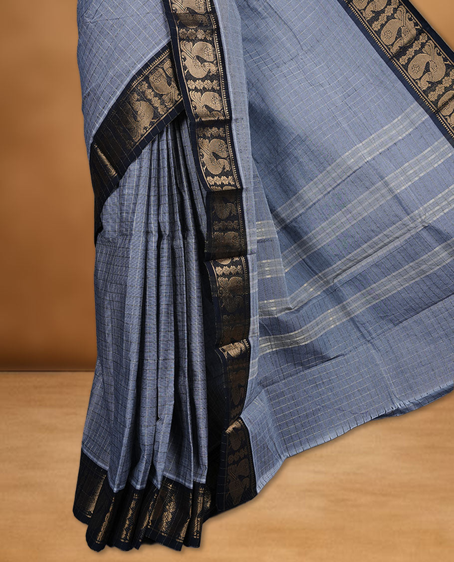 Grey colour sungudi cotton saree featuring gold zari check pattern across body, contrast Black colour with gold zari peacock and floral pattern on border, without blouse piece.