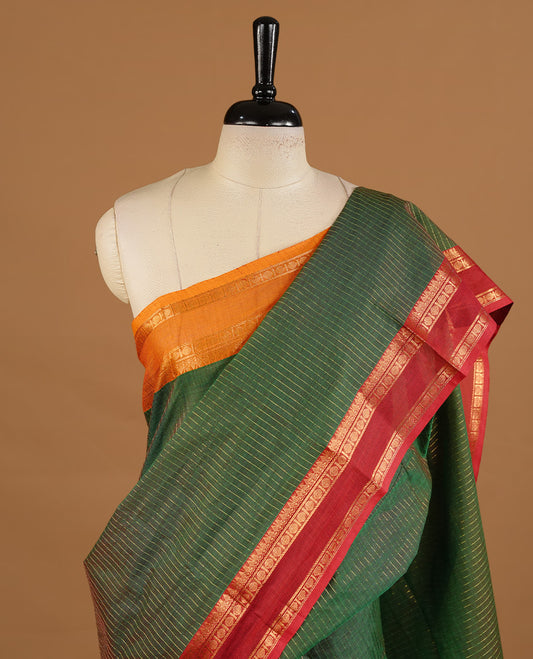 Green colour chettinad cotton saree featuring gold zari stripes on body, complemented by red colour with zari border, paired with matching blouse piece.