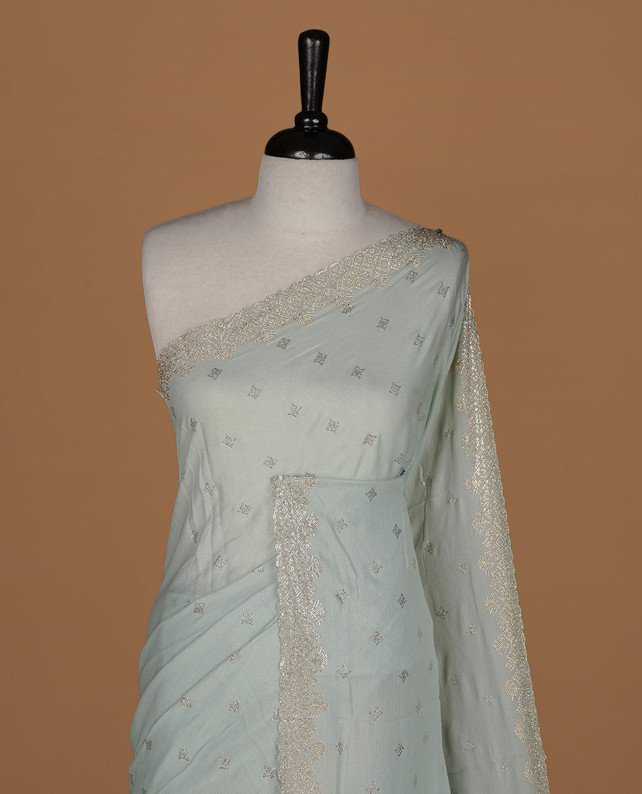 Mint colour organza designer saree featuring Gold stone motifs on body, highlighting light weight stone worked border, paired with matching blouse piece.