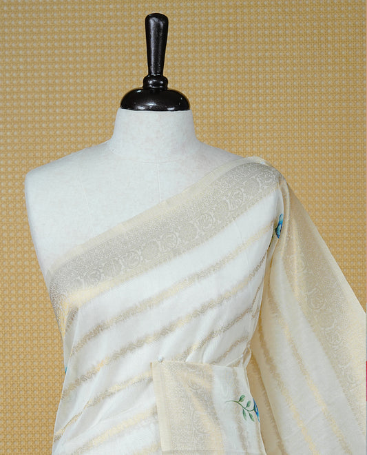 Cream Colour Organza Kerala Saree Featuring Gold Zari Strips with Floral Printed Motifs  On The Body,Paired With A Matching Blouse Piece.