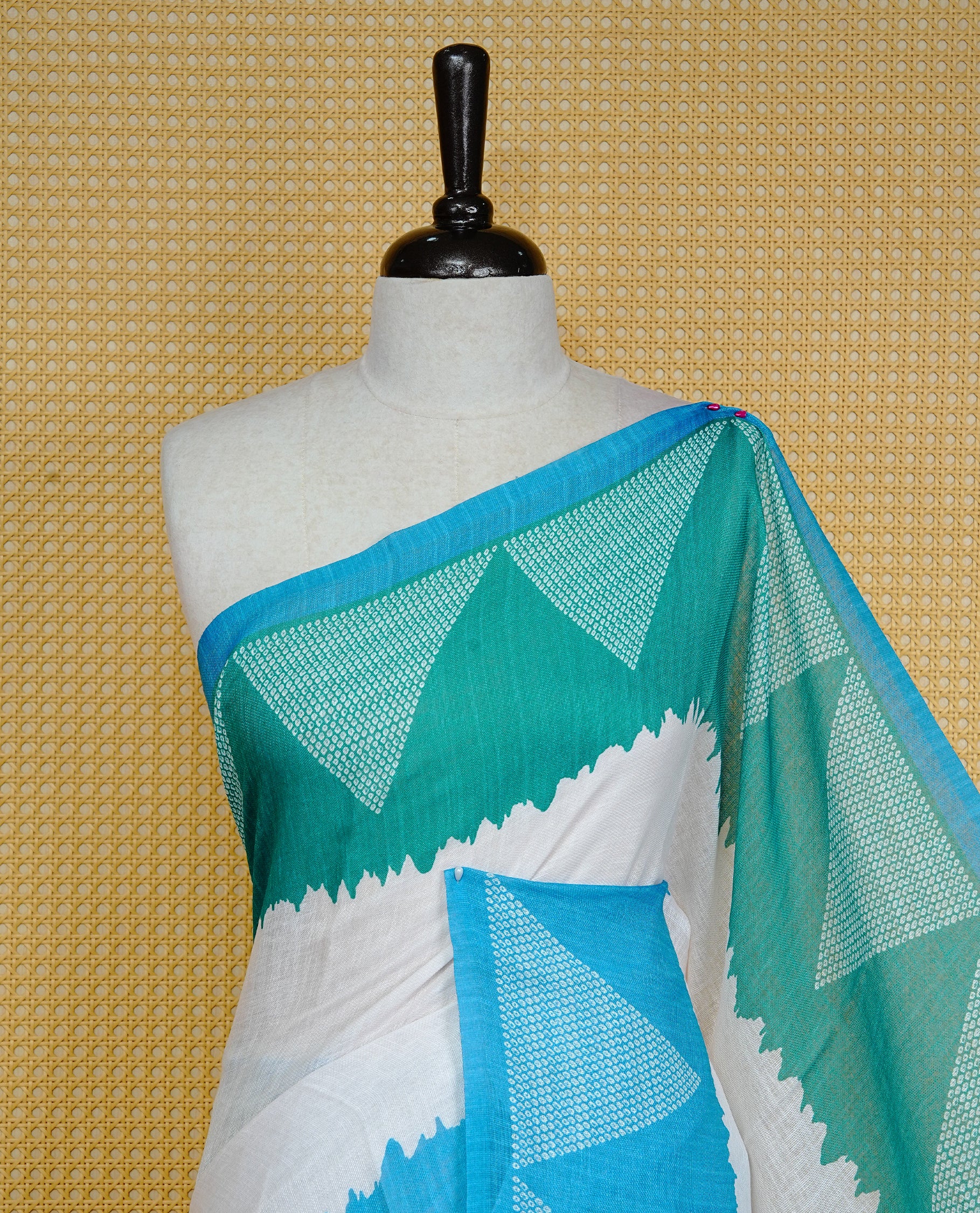 Cream colour semi linen saree featuring Blue Ajrakh pattern print on body, complemented by contrast Green colour with same pattern print Blue border, comes with matching blouse piece.
