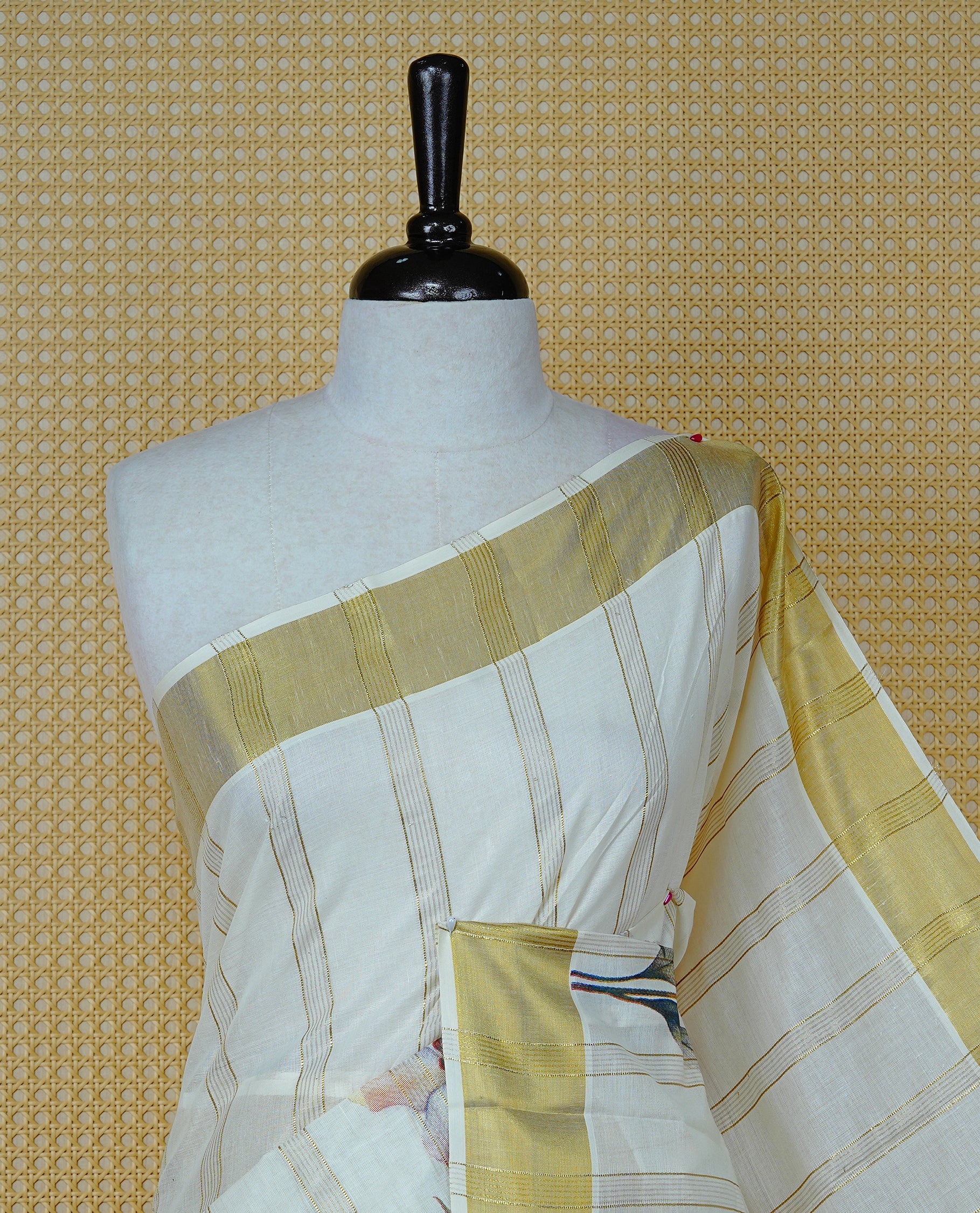 Cream Colour Cotton Kerala Sree Featuring Gold Zari Stripes On Body, Enrich Gold Zari With Floral Printed Border & Pallu, Paired With Matching Blouse Piece.