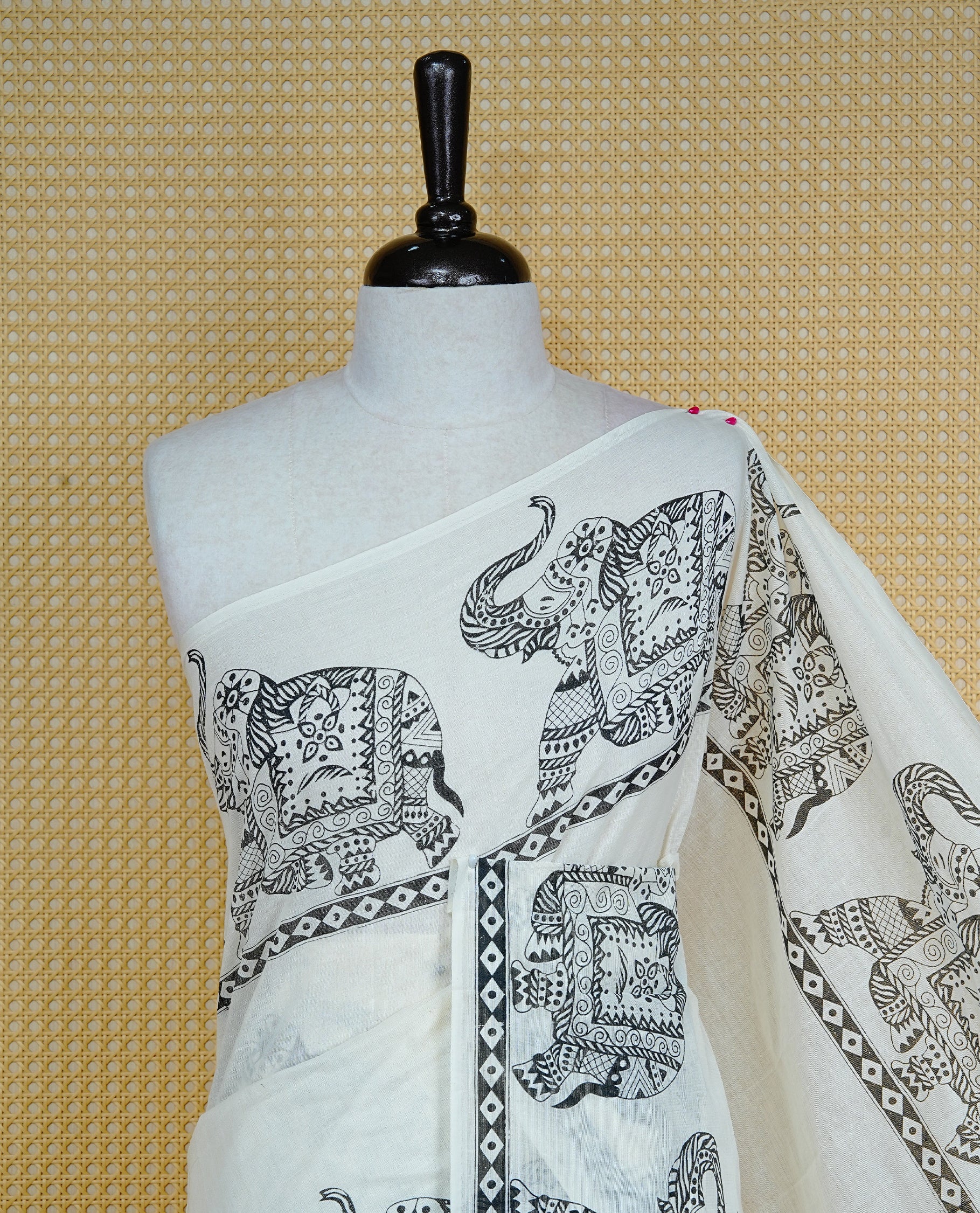 Cream colour Cotton kerala saree featuring Elegant plain body, complemented by Elephant print border, comes with matching blouse piece.