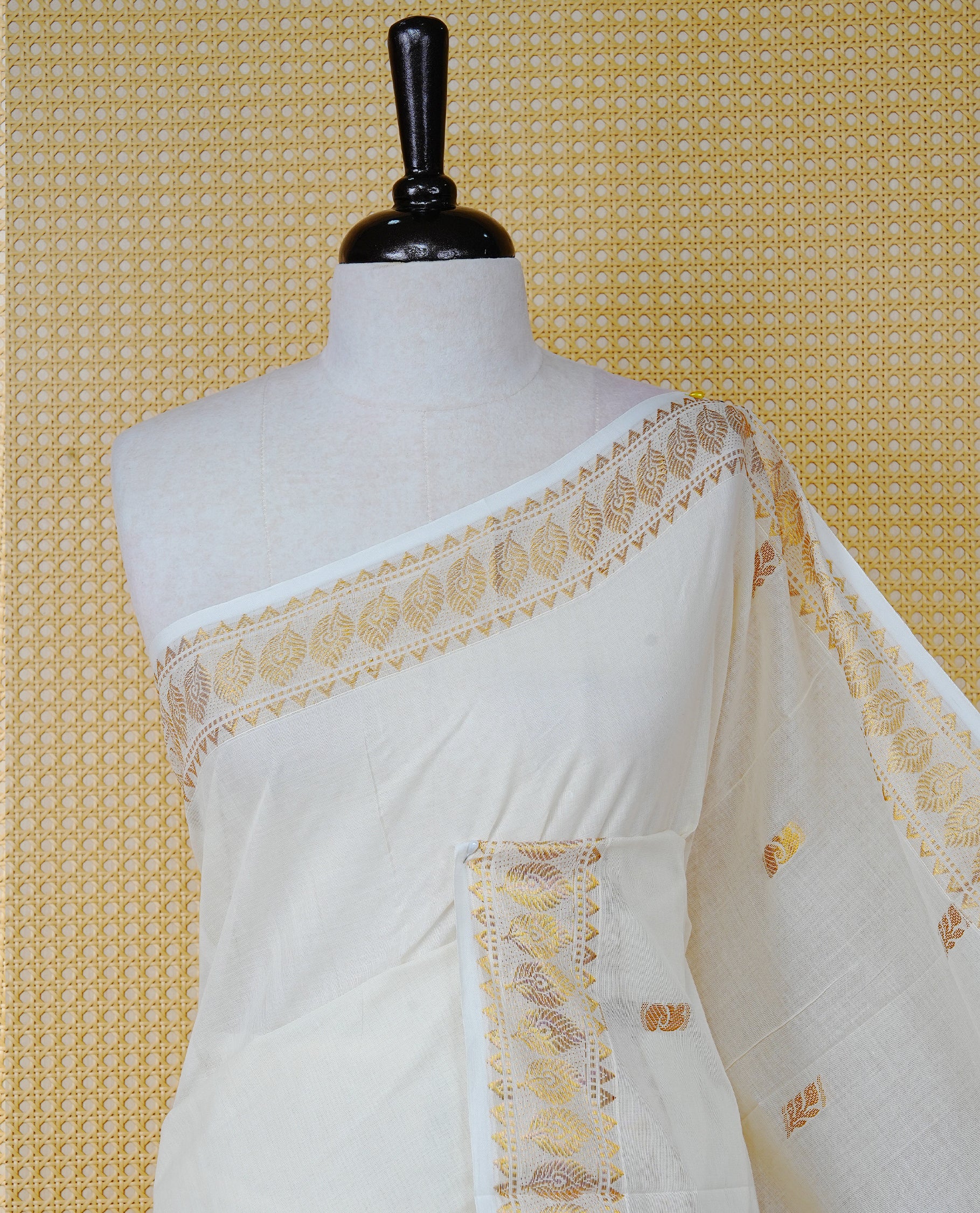 Cream Colour Cotton Kerala Saree Featuring Gold Buttas on the Body, a Classy Gold Zari Border, and a Traditional Maroon Colour Lord Krishna Thread work and Gold Zari Pallu, Paired with a Matching Blouse Piece.