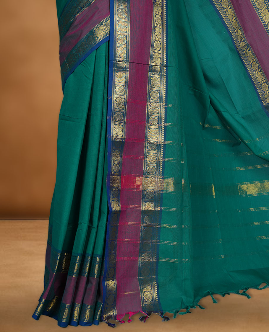 Green colour chettinad cotton saree featuring Elegant plain body highlighting contrast magenta and blue colour with gold zari traditional border, pallu and paired with matching blouse piece.