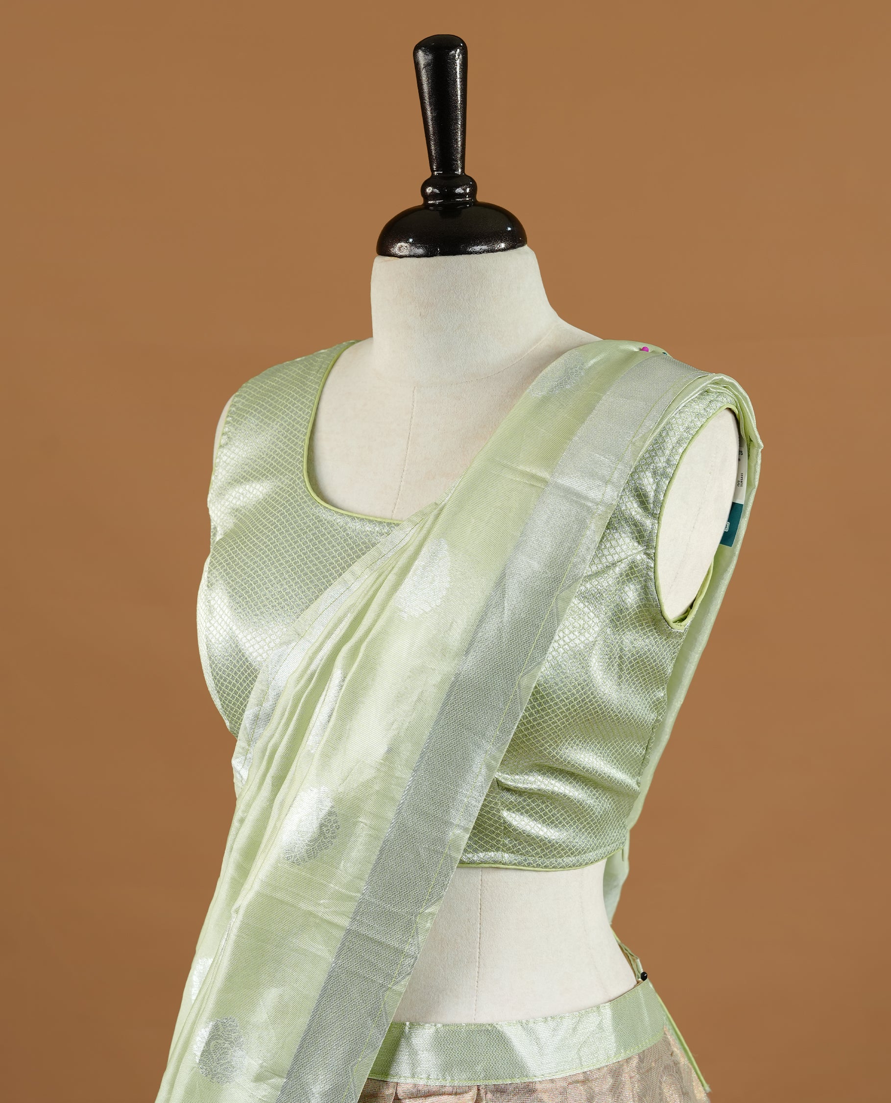 Pastel green colour Half saree featuring Antique colour skirt with contrast dusted gold colour border, paired with matching stitched blouse piece, with matching dupatta.