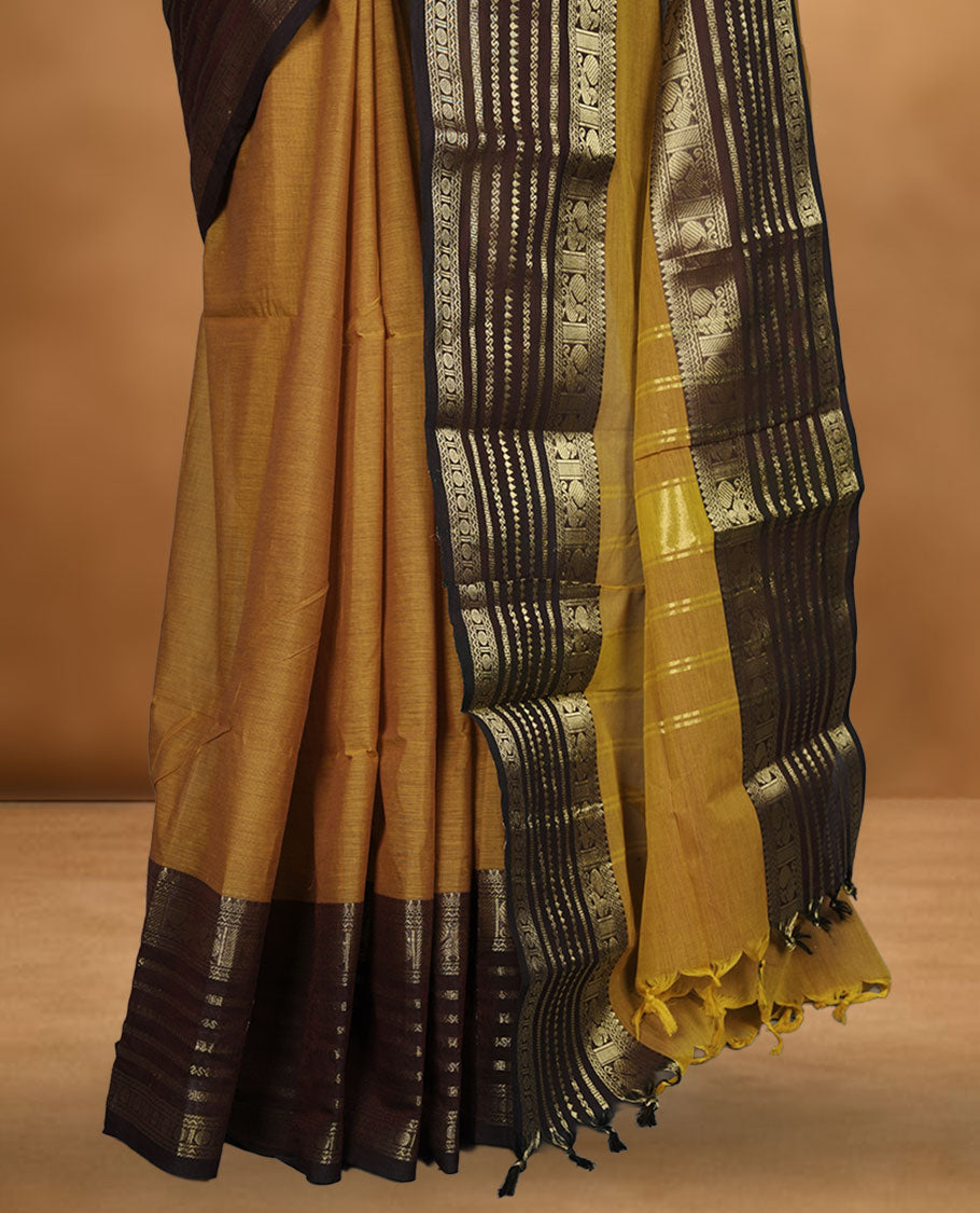 Dusty orange colour chettinad cotton saree featuring plain body, paired with a choclate brown colour traditional gold zari border paired with matching blouse.