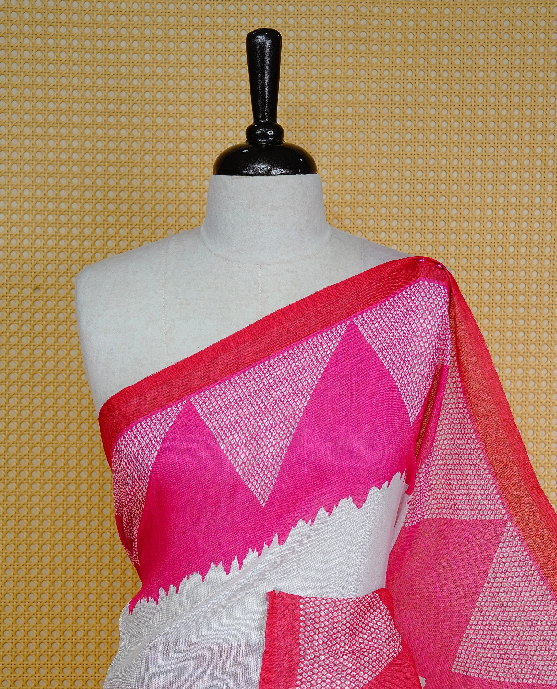 Cream colour semi linen saree featuring red Ajrakh pattern print on body, complemented by contrast Pink colour with same pattern print Red border, comes with matching blouse piece.