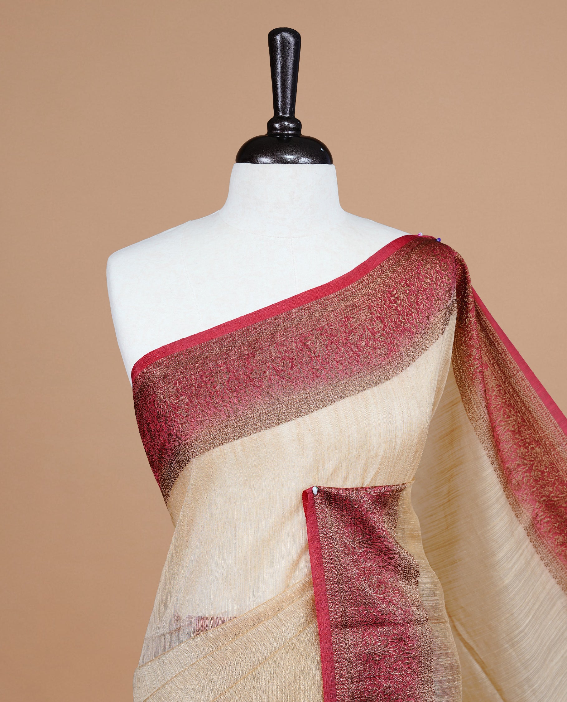 Biege colour Semi linen saree featuring Elegant plain body, complemented by contrast Maroon colour With Antique zari border, paired with matching blouse piece.