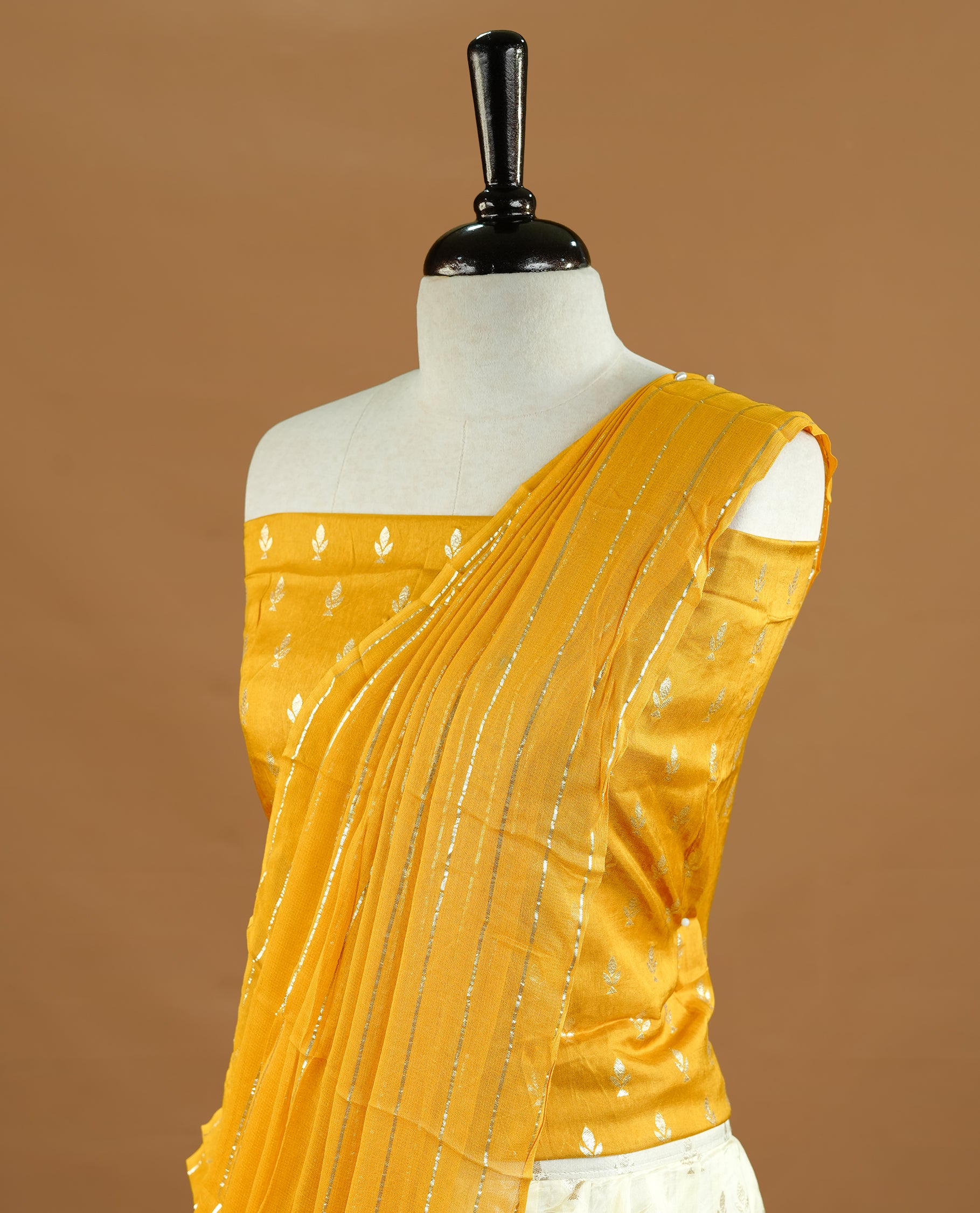 Off white colour semi stitched half saree featuring elegant zari buttas on the body, and contrast mustard colour with striped dupatta,paired with matching blouse piece.