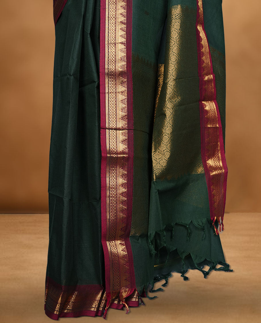 Dark green colour chettinad cotton saree featuring gold zari motifs on body, contrast Red colour with traditional gold zari border paired with matching blouse.
