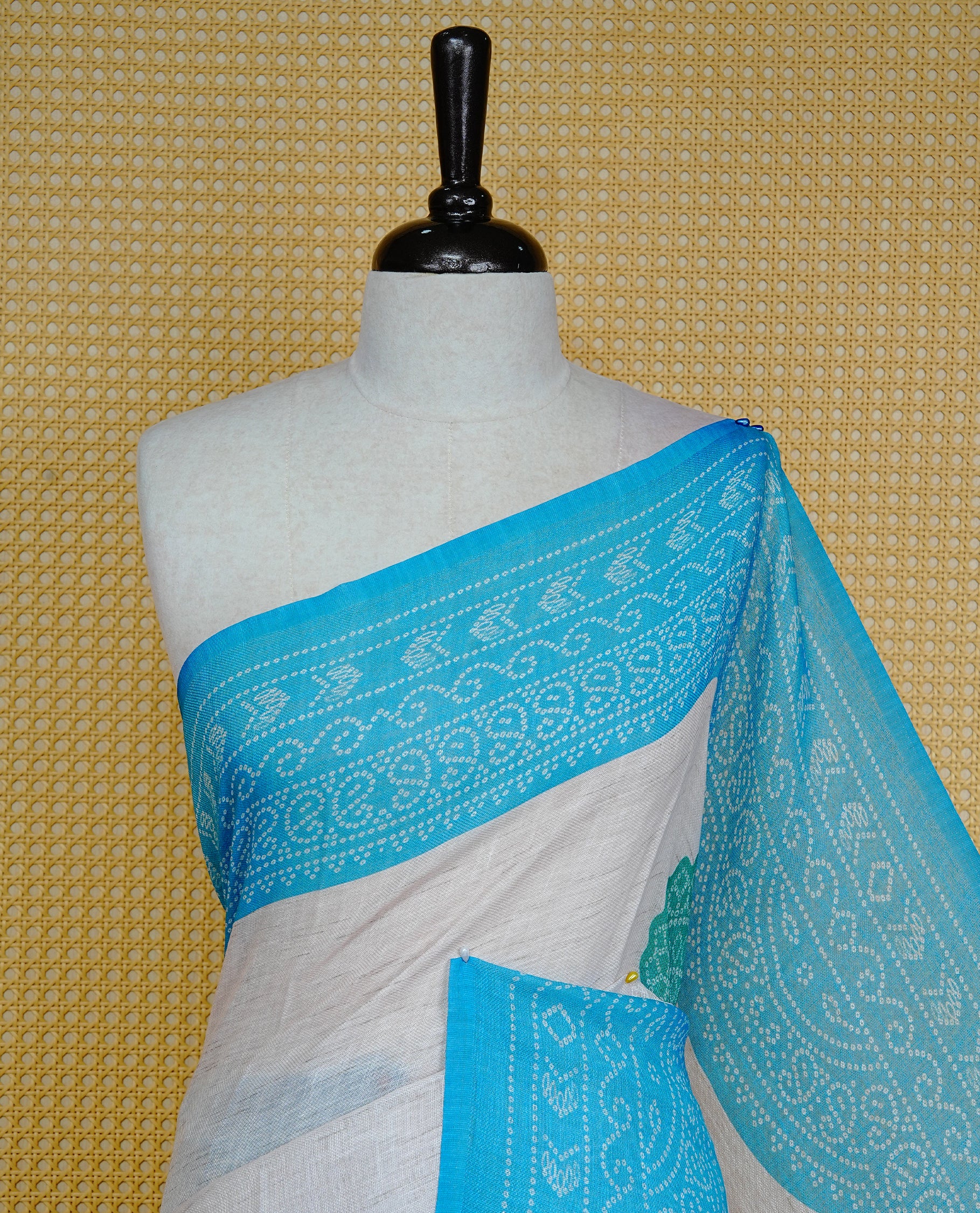 Cream colour semi linen saree featuring Green Ajrakh pattern print on body, complemented by contrast Blue colour with same pattern print border, comes with matching blouse piece.