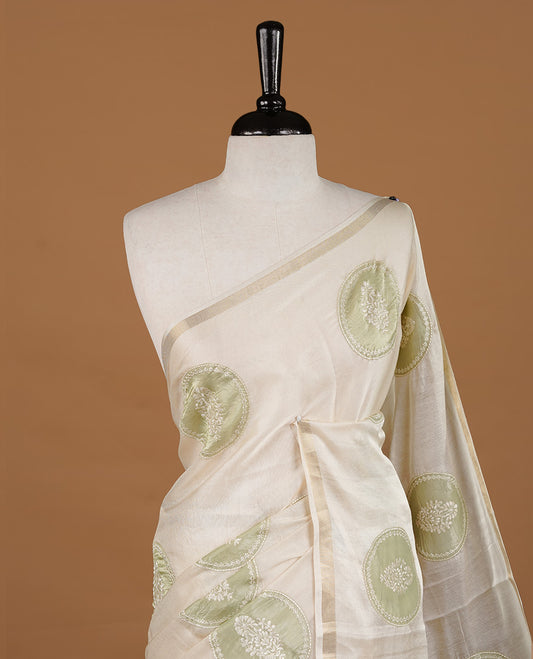 Cream colour Tussar saree featuring green colour circle pattern with chikankari embroidery work, highlighting gold zari simple border, paired with matching unstitched blouse.