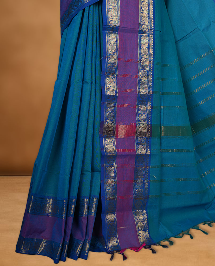 Aqua lake colour chettinad cotton saree featuring elegant plain body highlighting contrast magenta and blue colour with gold zari Peacock border, pallu and paired with matching blouse piece.