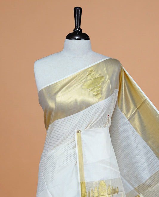 Cream Colour Cotton Kerala Saree Featuring Gold Strips  On The Body, Complemented By A  Gold Zari Circle Pattern On Border, Paired With A Matching Blouse Piece.