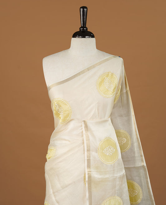 Cream colour Tussar saree featuring yellow colour circle pattern with chikankari embroidery work, highlighting gold zari simple border, paired with matching unstitched blouse.