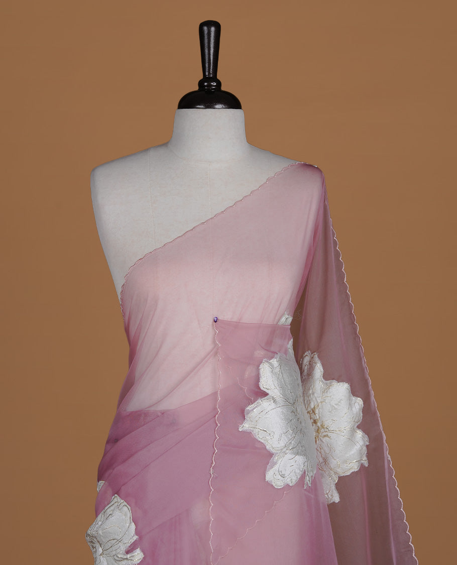 Pastel Mauve colour semi organza saree featuring white floral & gold thread pattern, highlighting scalp design border, paired with matching blouse piece.