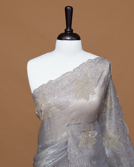 Grey colour Crush Organza Featuring Plain body, Enrich with Floral thread pattern with sequins & scalp border, paired with matching blouse piece.