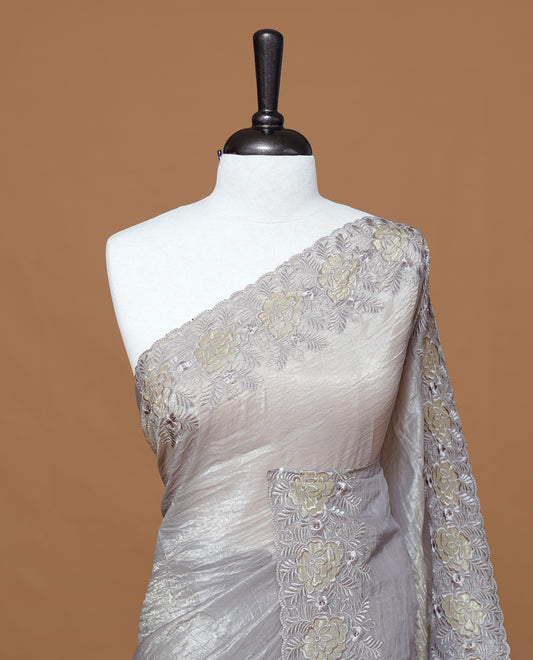 Grey colour Crush Organza Featuring Plain body, Enrich with Floral thread pattern & scalp border, paired with matching blouse piece.