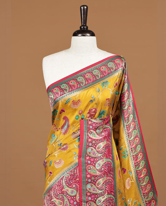 Mustard yellow colour Pashmina silk saree features an all over floral body, a contrast crimson red paisley border and pallu, and a matching unstitched blouse.