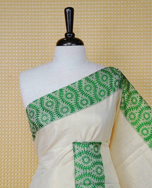 Cream Colour Tissue Kerala Saree Featuring a Plain Body, Enhanced with Green Block  Printed Borders, a Green and Gold Zari Pallu, Green Tassels, and a Matching Blouse Piece.