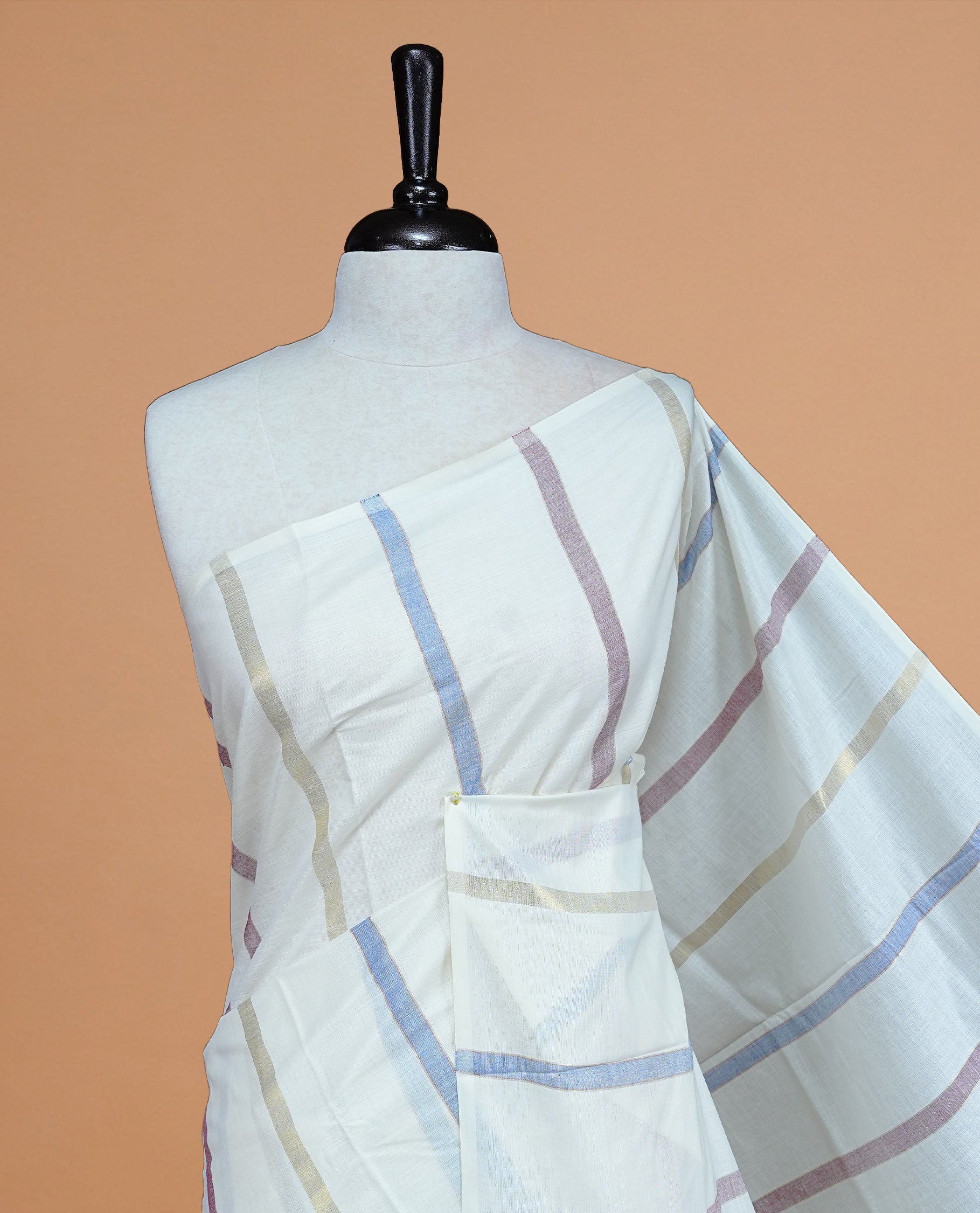 Cream Colour Cotton Kerala Saree Featuring Periwinkle  Blue & Light  Purple Strips On The Body & Pallu, Paired With A Matching Blouse Piece.