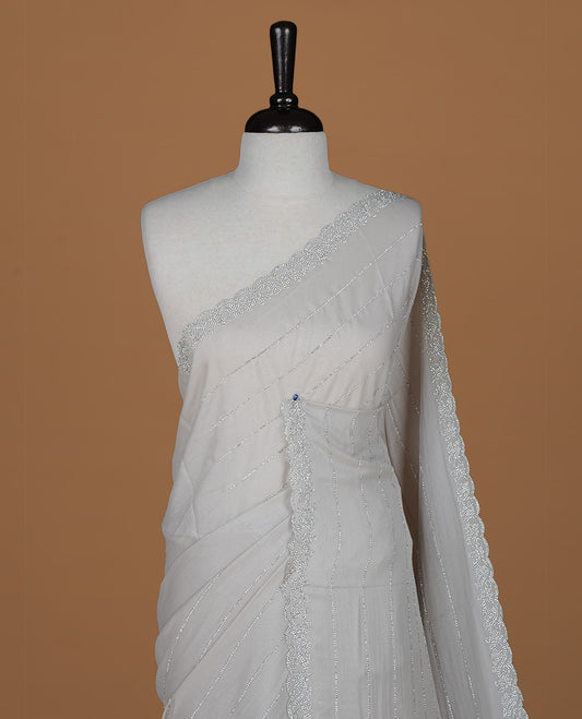 Grey colour designer saree featuring white stone stripes on body, highlighting white stone with scalp border, paired with matching blouse piece.