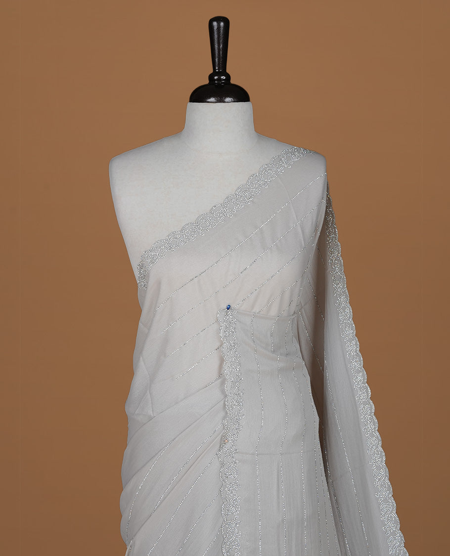 Grey colour designer saree featuring white stone stripes on body, highlighting white stone with scalp border, paired with matching blouse piece.