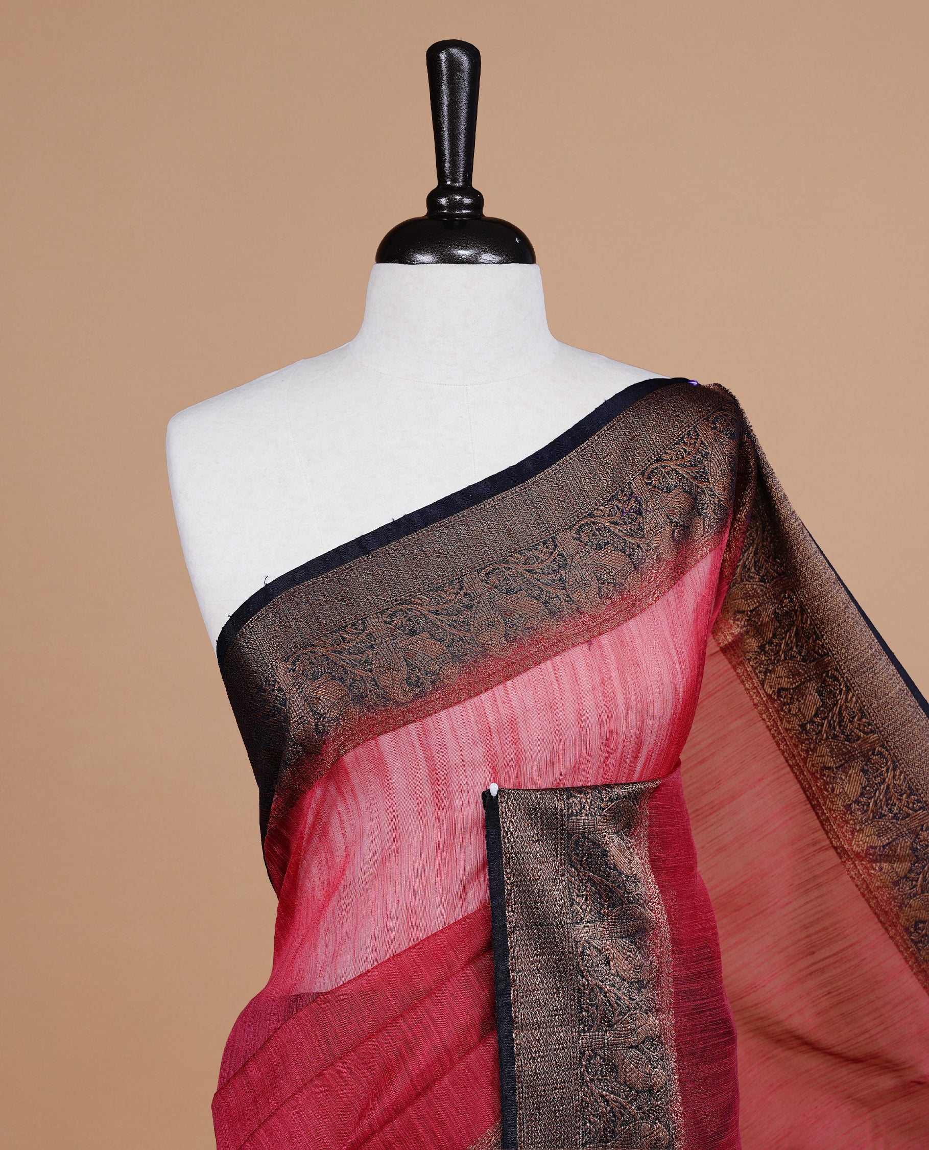 Saffron red colour Semi linen saree featuring Elegant plain body, complemented by contrast Navy Blue colour With Antique zari border, paired with matching blouse piece.