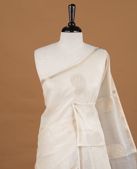 Cream colour Tussar saree featuring cream colour Mango pattern with chikankari embroidery work, highlighting gold zari simple border, paired with matching unstitched blouse.