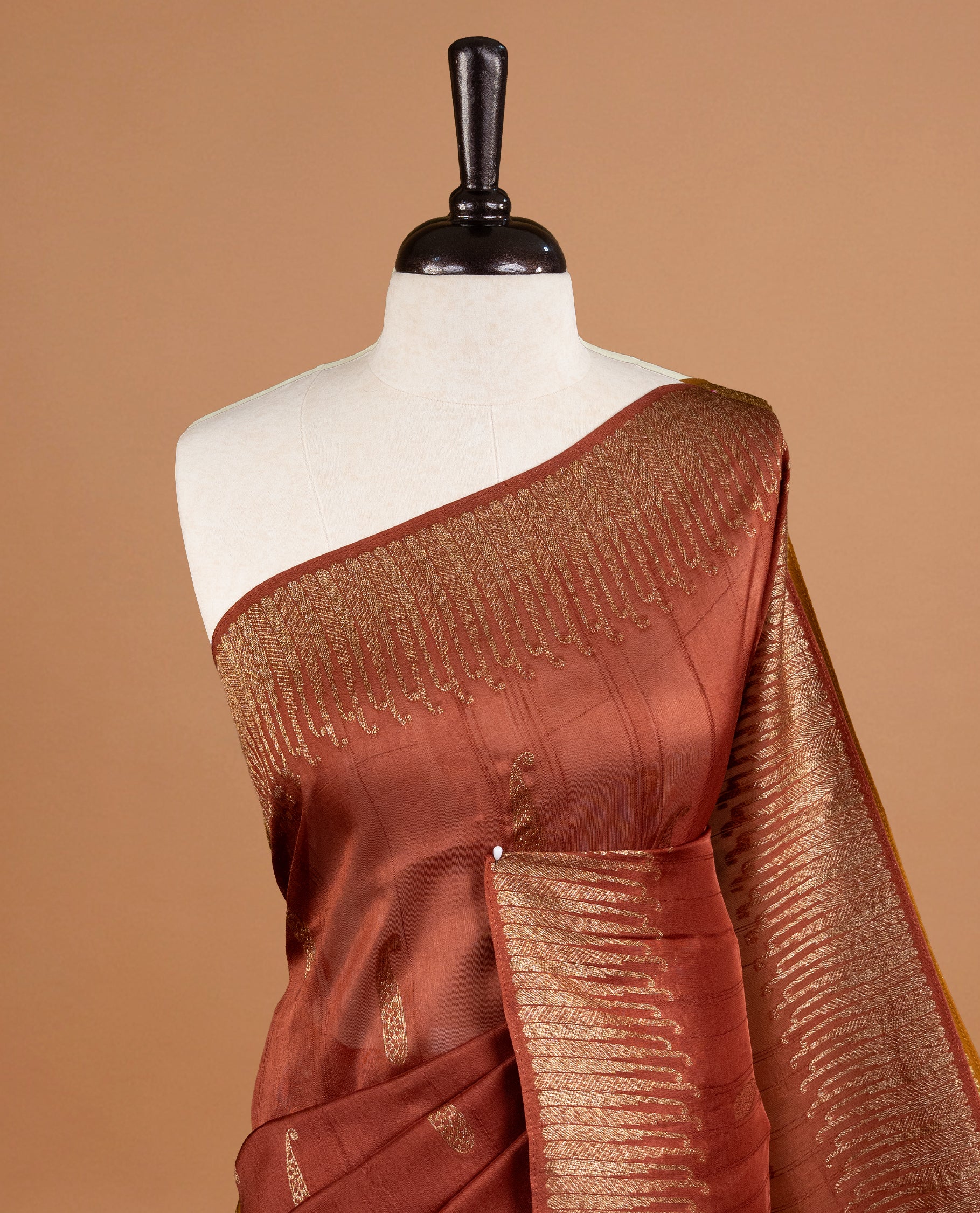 Brown colour Semi Banaras Tussar Georgette Featuring Gold zari Leaf pattern on body, Finished with Gold zari border and paired with matching blouse piece.