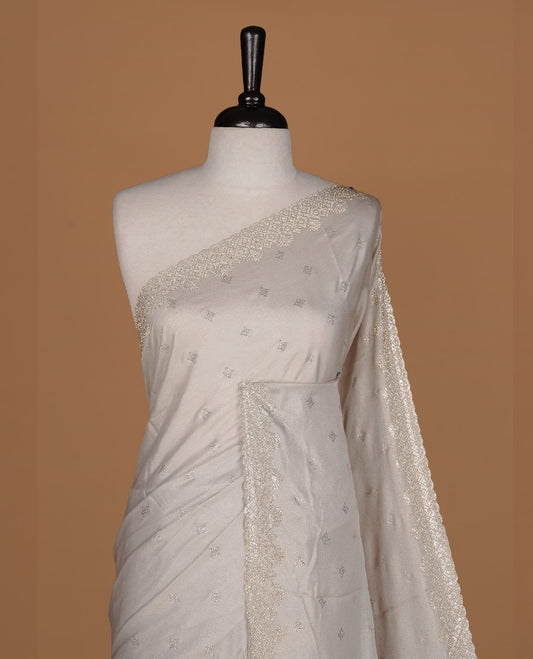 Off white colour organza designer saree featuring Gold stone motifs on body, highlighting light weight stone worked border, paired with matching blouse piece.