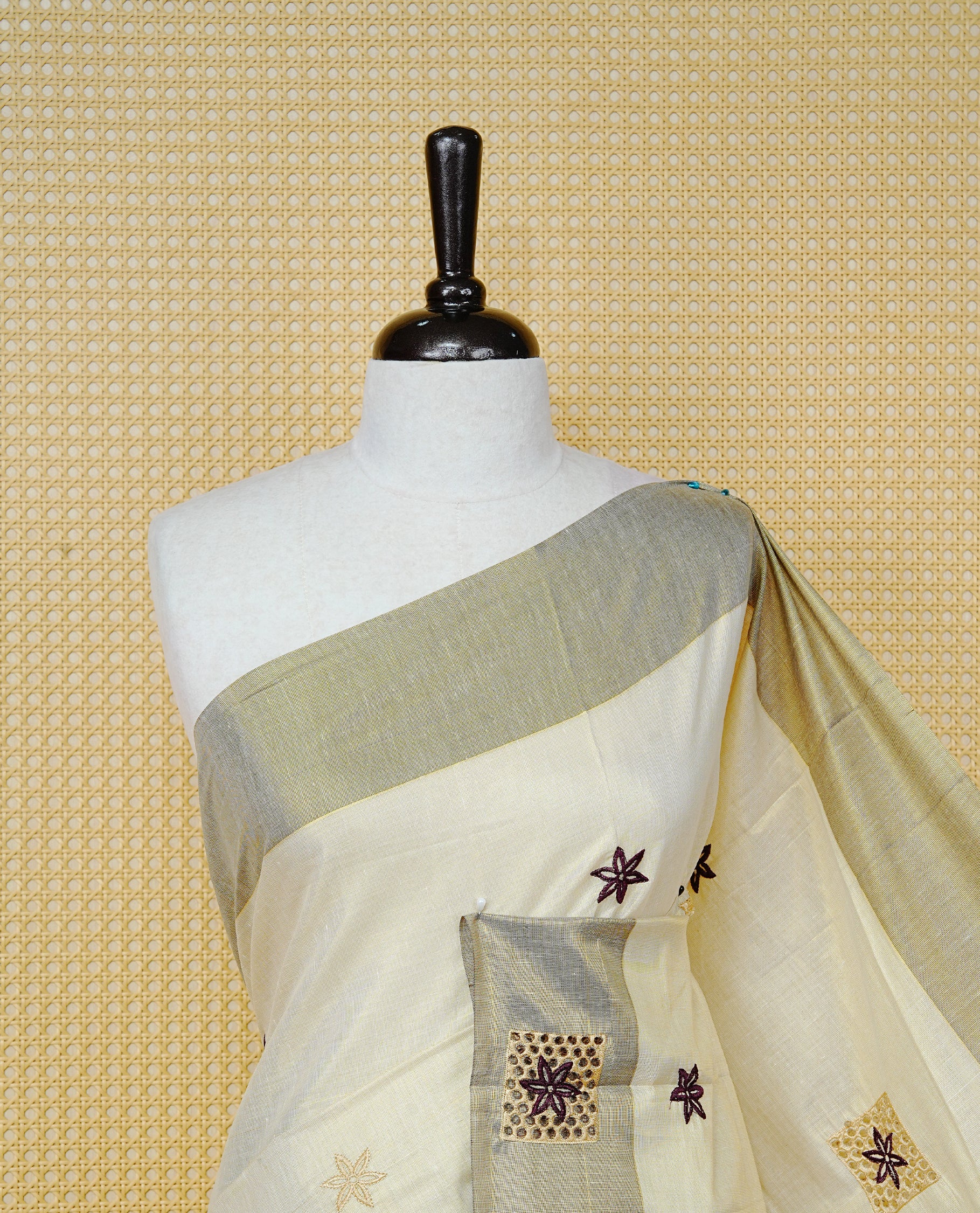 Cream Colour Tissue Kerala Saree Featuring Delicate Maroon Floral Embroidery Work Across The Body, Enhanced With A Light maroon Zari Border And A Rich Maroon & Gold Zari Pallu, Finished With Maroon Tassels And A Matching Blouse Piece