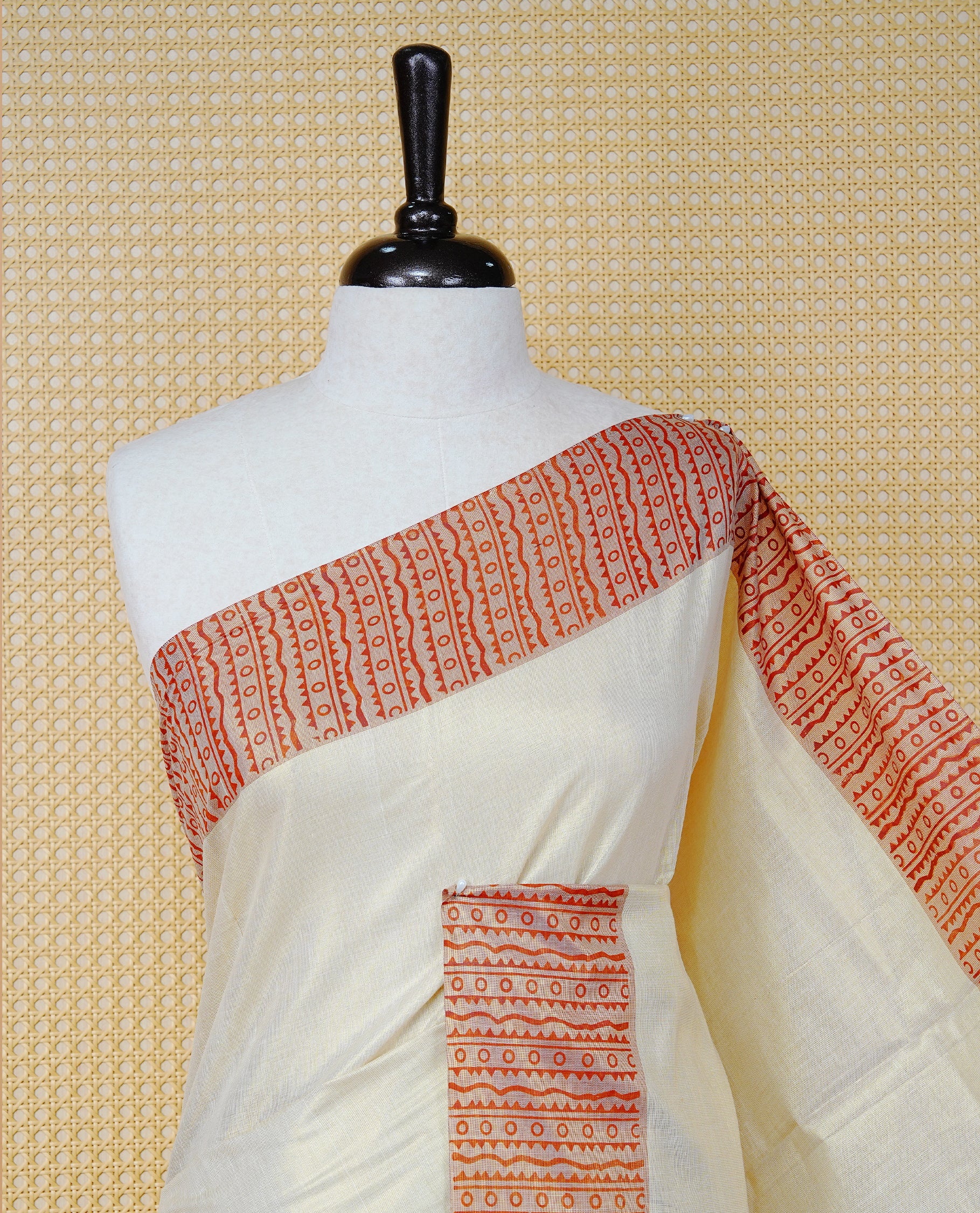 Cream Colour Tissue Kerala Saree Featuring a Striking Rust Red Printed Border with Traditional Geometric Motifs. The Rich Rust Pallu Is Accentuated with Gold Zari Detailing and Finished with Matching Tassels, Paired with a Matching Blouse Piece.