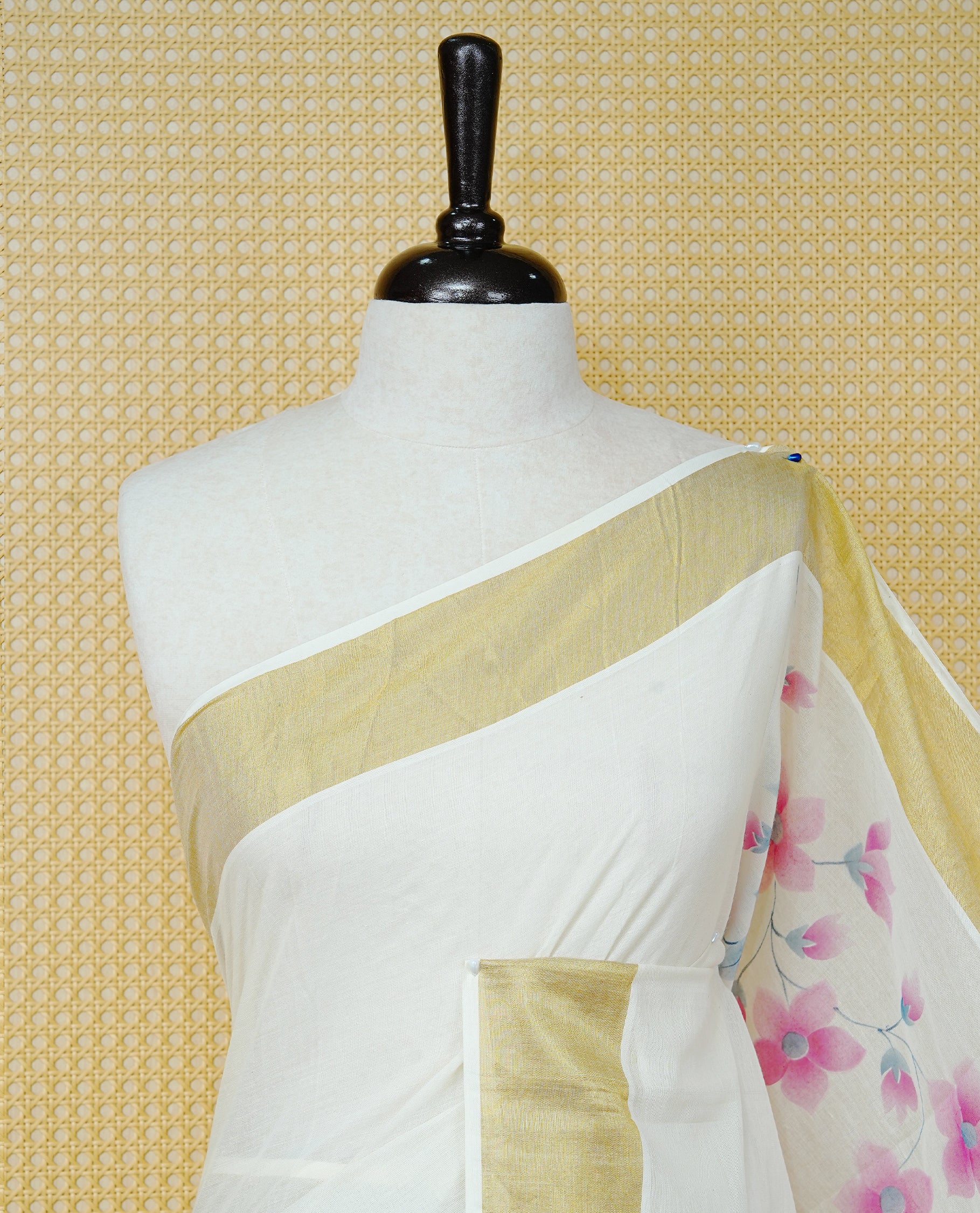 Cream Colour Cotton Kerala Saree Featuring Digital Pink Floral Prints Across The Body, Enhanced With A Gold Zari Border, Traditional Gold Zari Pallu, Finished With Pink & White Tassels And A Matching Blouse Piece
