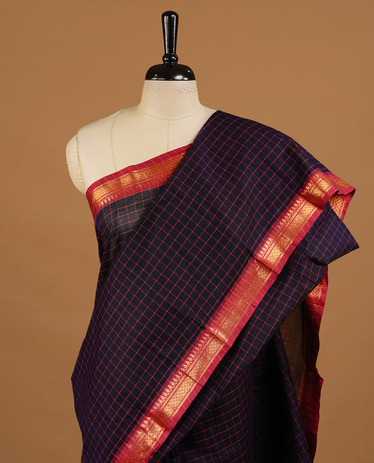 Dark blue colour chettinad cotton saree featuring  Check pattern  on body, complemented by magenta colour with zari border, paired with matching blouse piece.