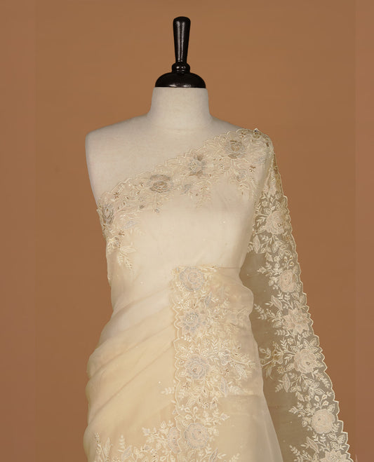 Pastel yellow colour organza saree featuring thread with cut beats & sequins floral pattern on body, highlighting scalp border, paired with matching blouse piece.