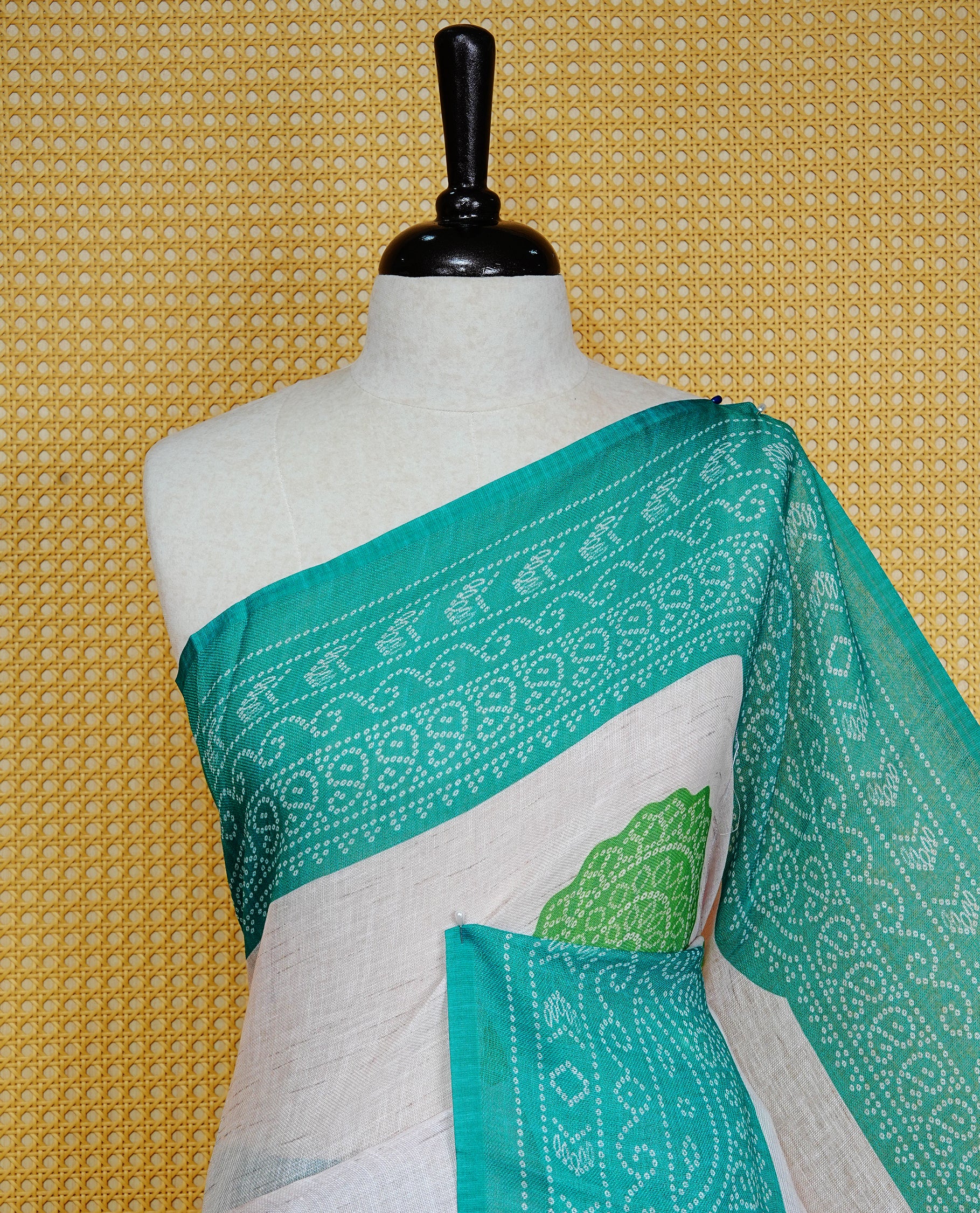 Cream colour semi linen saree featuring Light green Ajrakh pattern print on body, complemented by contrast green colour with same pattern print border, comes with matching blouse piece.