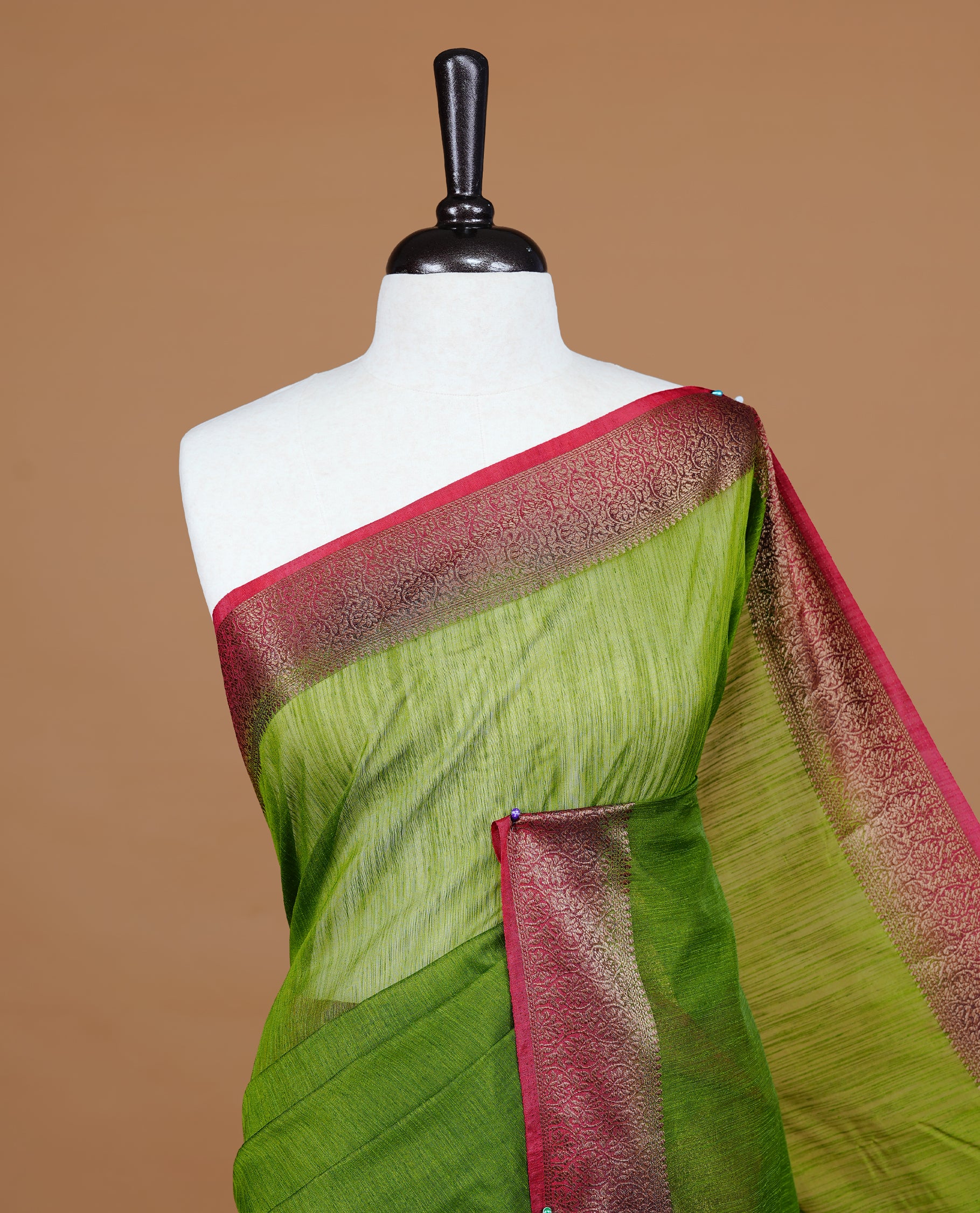 Green colour Semi linen saree featuring Elegant plain body, complemented by contrast Maroon colour With Antique zari border, paired with matching blouse piece.